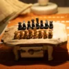 Olive wood chess pieces on irregular rustic board, close-up view